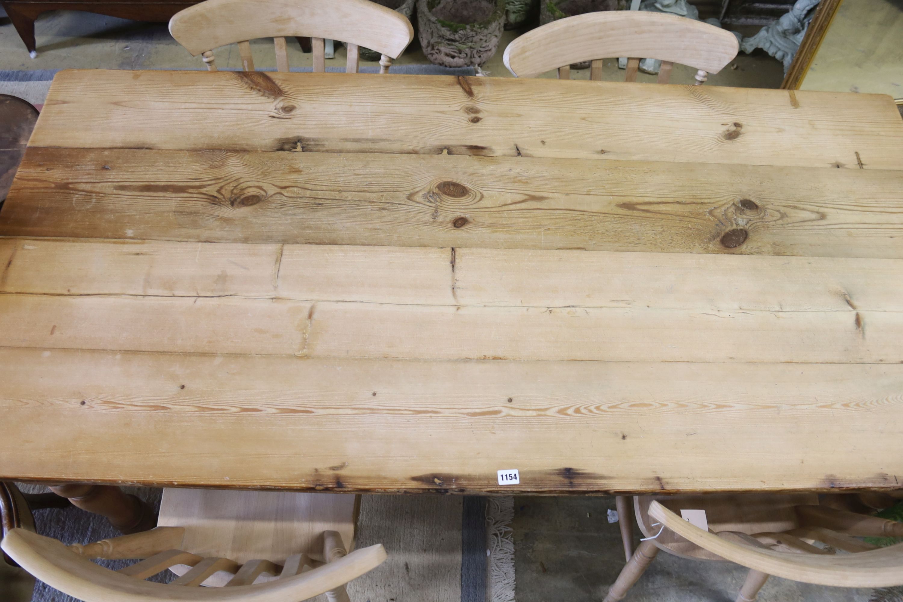 A pine 'farmhouse' kitchen table, length 183cm, depth 87cm, height 78cm fitted single end drawer and a set of four Windsor beech chairs